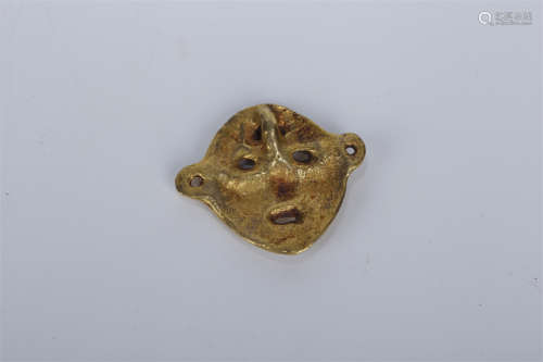 A Gilt Copper Mask Pendant.