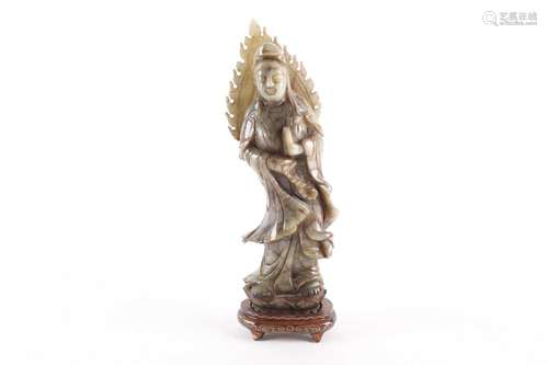 A carved soapstone figure of Guanyin, on an oval hardwood ba...