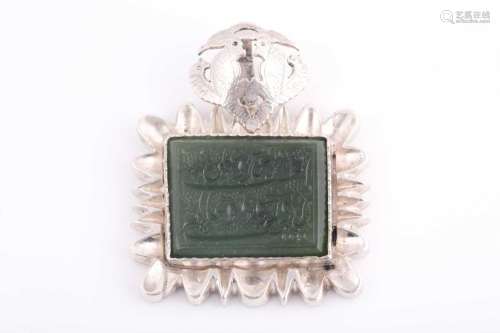 An Indo Persian white metal and jade pendant, the jaded engr...