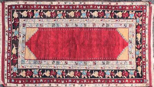 An early 20th-century crimson red ground Turkish rug with an...