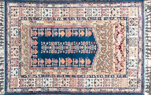 A 20th-century blue ground Turkish prayer rug with a slightl...