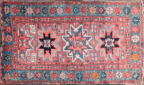 An old red ground Kazak rug with three-star for lozenges on ...