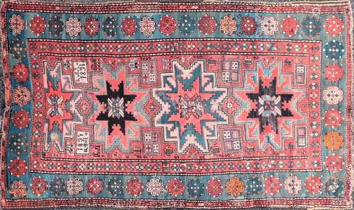 An old red ground Kazak rug with three-star for lozenges on ...