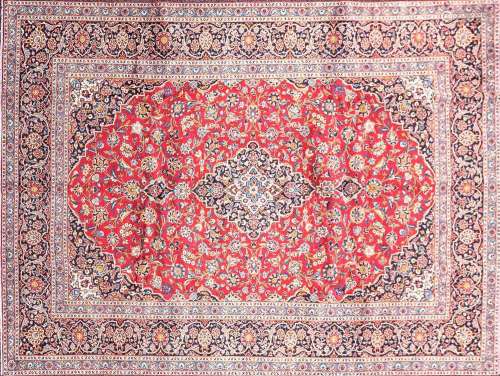 A 20th-century red ground Kashan carpet, with a central meda...