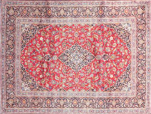 A 20th-century red ground Kashan carpet, with a central meda...