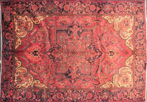 A 20th-century red ground Heriz carpet. With a central geome...