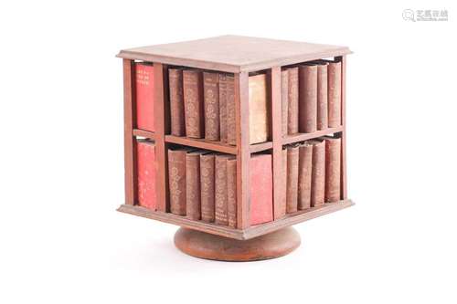 A 19th-century revolving miniature bookcase, containing mini...