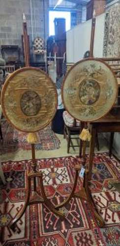 A pair of 19th century mahogany pole screens, with oval silk...