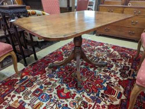 A Regency banded mahogany rectangular tilt top dining table,...