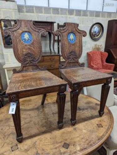 A pair of Victorian oak hall chairs with painted armorials, ...