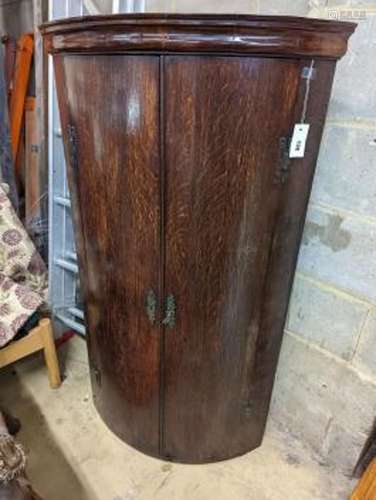 A George III oak bow-fronted hanging corner cabinet, width 7...