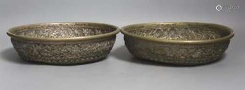 A pair of Indonesian embossed silvered metal circular bowls,...