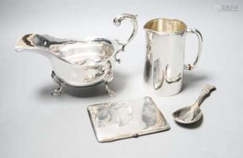 A George V silver sauceboat, a silver jug with military rela...