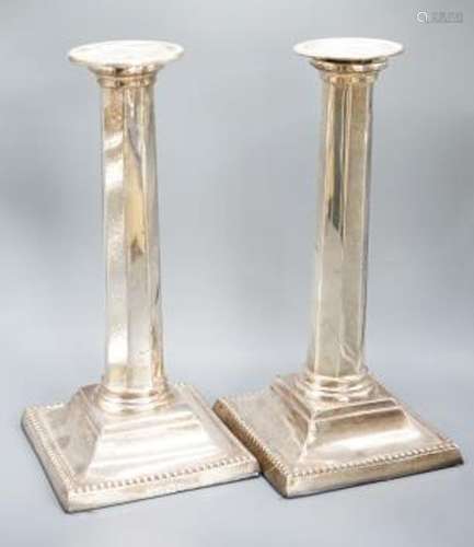 A pair of Edwardian silver candlesticks, with panelled colum...