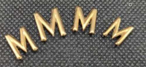 Four yellow metal letter 'M' appliques, gross weight 2.4 gra...