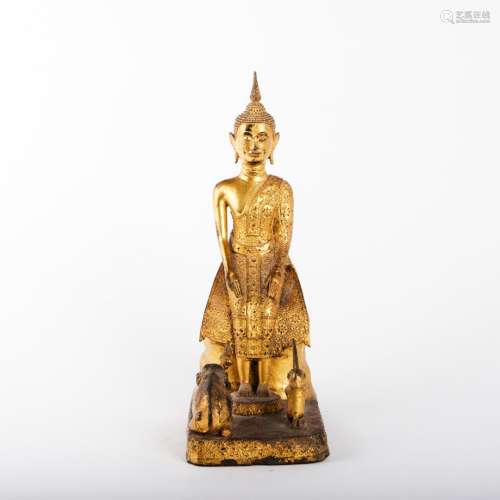 Bouddha en bronze assis sur un rocher Devant lui, un éléphan...