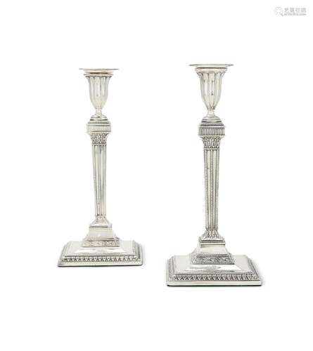 A pair of George III silver candlesticks of neo-classical fo...