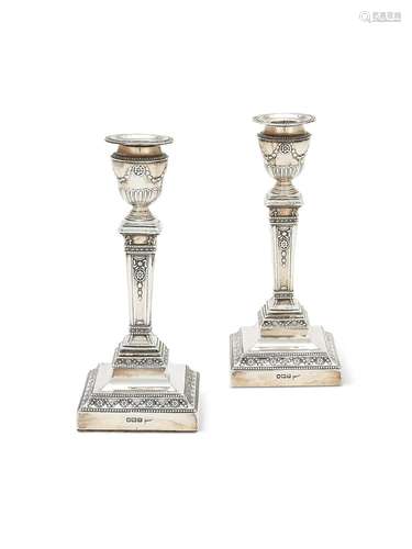 A pair of Edwardian silver candlesticks by Walker and Hall, ...