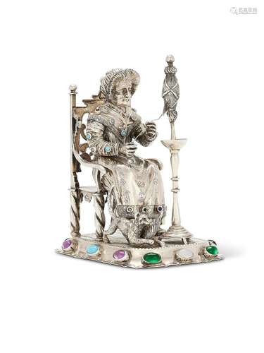 A German silver ornament of an old lady sitting spinning whi...