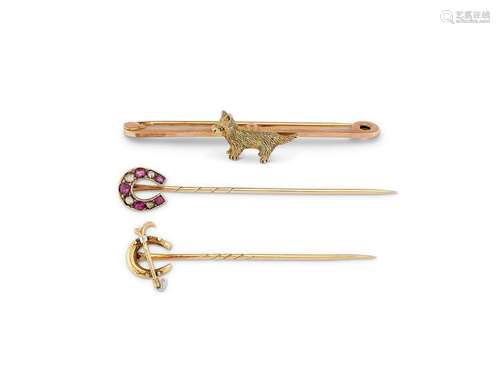 A gold tie clip centred by a Highland terrier and two stick ...