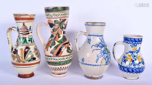 FOUR EASTERN EUROPEAN TIN GLAZED POTTERY JUGS in various for...