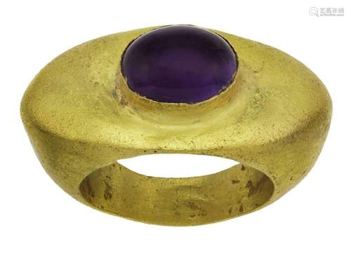 An amethyst ring, in the Roman style, centring on an oval ca...