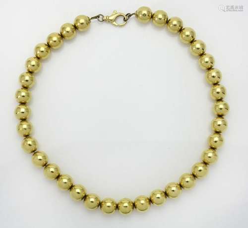 A bead necklace, composed of a uniform row of polished beads...