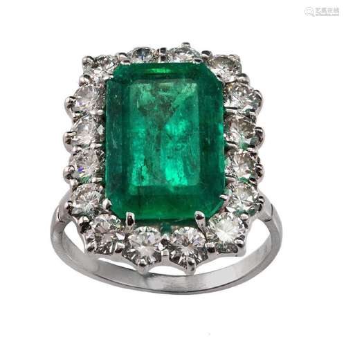 An Emerald and diamond ring, claw set with a rectangular cut...