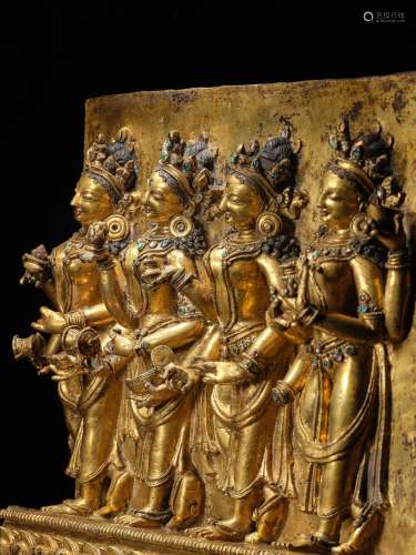 A CAST GILT COPPER ALLOY PANEL WITH OFFERING GODDESSES