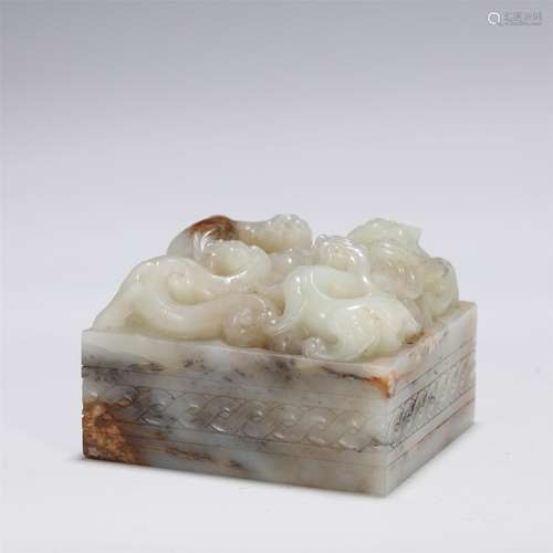 A Carved White and Russet Jade Beast Seal