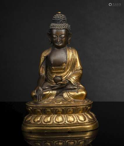 A PART-GILT BRONZE FIGURE OF BUDDHA SHAKYAMUNI HOLDING HIS A...