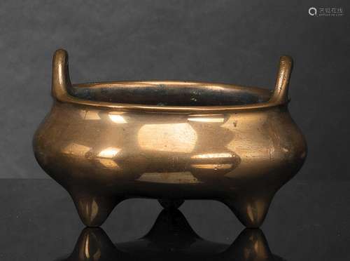 A GOLD-COLORED BRONZE TRIPOD CENSER