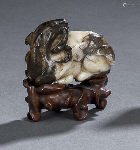 A FINE CARVED BLACK AND CREAM JADE DEER WITH BAT AND LINGZHI...