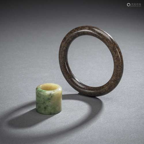 A GREY-BROWN AND BLACK JADE BANGLE AND A JADE ARCHER'S ...