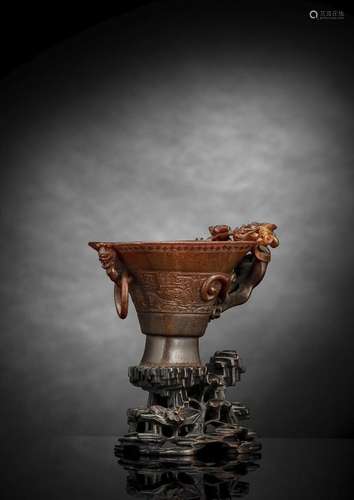 A VERY FINE CARVED BROWN RHINOCEROS WINE CUP WITH TAOTIE MAS...