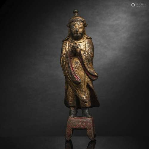 A GILT-BRONZE FIGURE OF A STANDING GUARDIAN