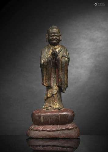 A GILT-BRONZE FIGURE OF A LUOHAN STANDING ON A LOTUS BASE