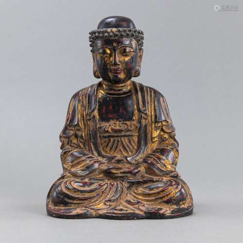A WOOD CARVING OF BUDDHA WITH REMNANTS OF GILDING AND PAINTI...