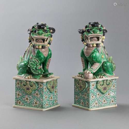 A PAIR OF FO DOGS WITH FAMILLE VERTE DECOR ON A HIGH BASE WI...