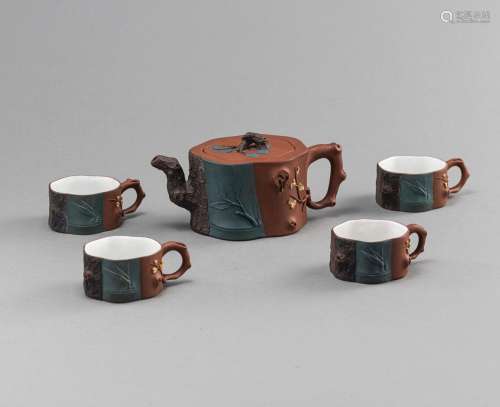 A ZISHA MOLDED TEAPOT AND COVER AND FOUR CUPS