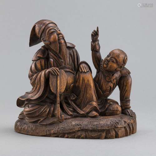 A WOOD CARVING OF A SCHOLAR AND A BOY