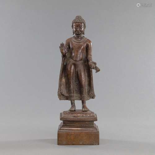 A BRONZE FIGURE OF BUDDHA STANDING ON A LOTUS