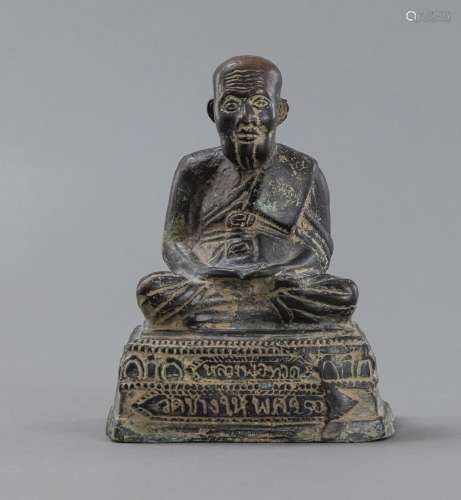 A BRONZE MODEL OF A SEATED MONK WITH INSCRIPTION