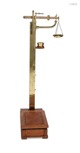 AN EDWARDIAN OAK AND BRASS PERSONAL WEIGHING SCALES BY W. &a...