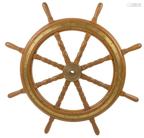 A large wooden steering wheel originating from the flight de...