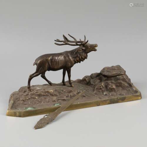 A large bronze ink well with a sculpture of a burling stag.
