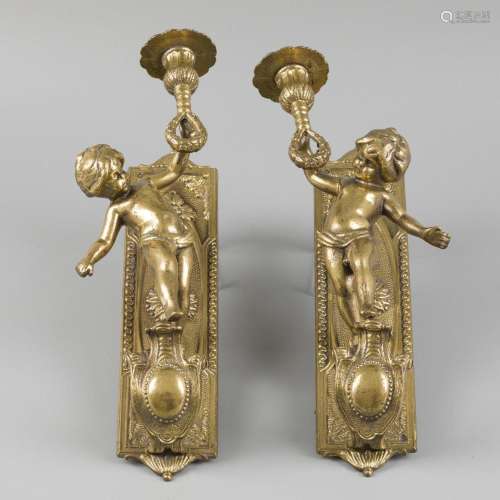 A lot comprising (2) candlestick holders, adorned with putto...