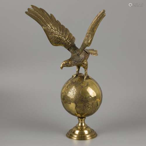 A brass cast of an eagle on a terrestial globe.
