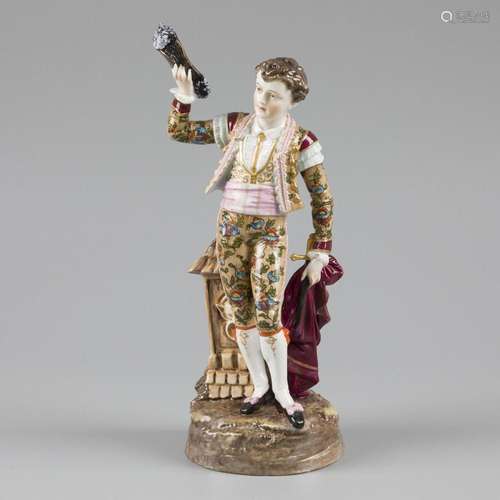 A porcelain sculpture of a boy holding a hat and a sabre, ma...