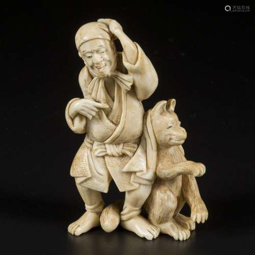 An ivory okimono depciting an old man and a wolf, Japan, Mei...